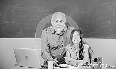 Modern knowledge. Modern teaching method. Student girl with teacher man at blackboard. Schoolgirl and tutor with laptop Stock Photo