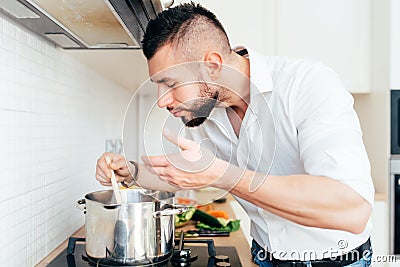 Modern lifestyle with man cooking soup and preparing dinner. Master chef preparing food Stock Photo