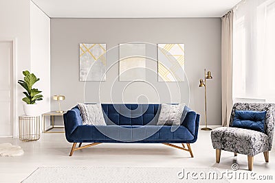 A modern living room interior of a luxurious hotel apartment with a designer couch, an armchair and art decorations. Real photo. Stock Photo