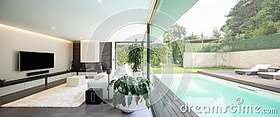 Modern living room overlooking the garden and swimming pool. Stock Photo