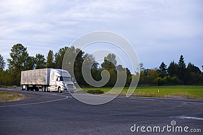 Modern long haul semi truck tarp trailer on straight highway Stock Photo