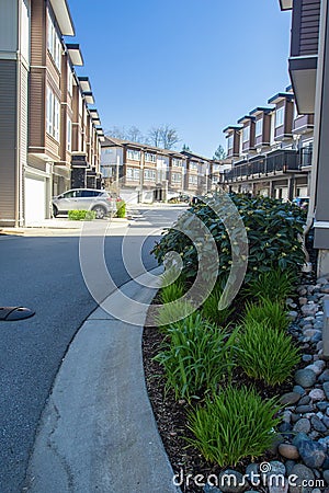 Modern low rise wood frame complex. Brand new apartment building on sunny day in spring with blooming trees. Stock Photo