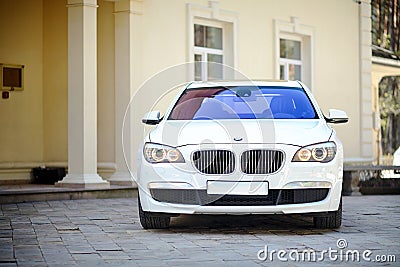 Modern luxury BMW 750Li XDrive car front view parked on stone paved parking near ancient house horizontal Editorial Stock Photo