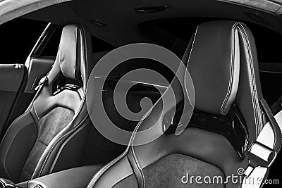 Modern Luxury sport car inside. Interior of prestige modern car. Comfortable leather seats with stitching. Black perforated leathe Stock Photo