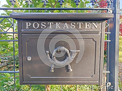 Modern mailbox with posthorn symbol Stock Photo