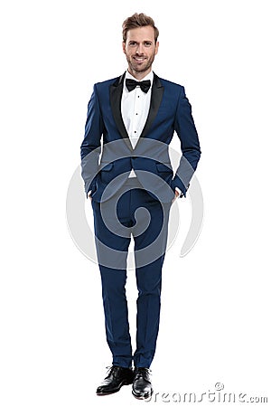 Modern man in blue tuxedo standing with hands in pockets Stock Photo