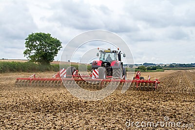 Modern massey ferguson tractor cultivating field Editorial Stock Photo