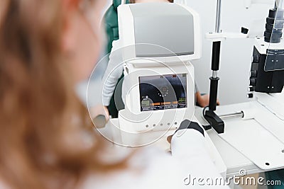 Modern medical equipment. Close up of ophthalmologist using auto refractometer while examining child eyes. Stock Photo