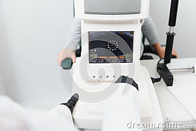 Modern medical equipment. Close up of ophthalmologist using auto refractometer while examining child eyes. Stock Photo