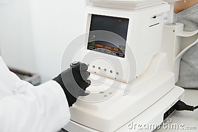 Modern medical equipment. Close up of ophthalmologist using auto refractometer while examining child eyes. Stock Photo