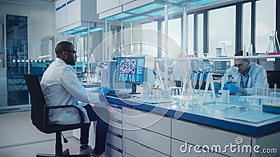 Modern Medical Laboratory: Male Scientist, Typing on Keyboard working on Computer, Scren Shows DNA Stock Photo