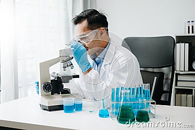 Modern medical research laboratory. male scientist working with micro pipettes analyzing biochemical samples, advanced science Stock Photo