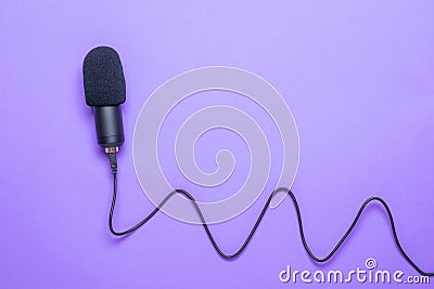 Modern microphone with a long cord on a purple background Stock Photo