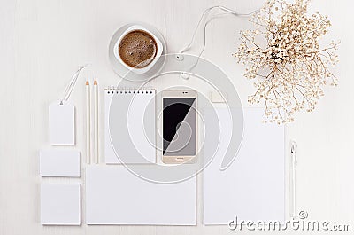 Modern minimalistic elegant feminine work space with white blank stationery, coffee, flowers, phone on white wood board. Stock Photo