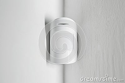 Modern motion sensor on wall indoors Stock Photo