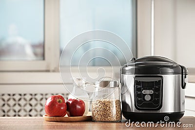 Modern multi cooker and products on table in kitchen Stock Photo