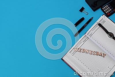 Modern office desk workplace with blank notebook, pen and supplies. Copy space on blue background. Top view. Flat lay Stock Photo