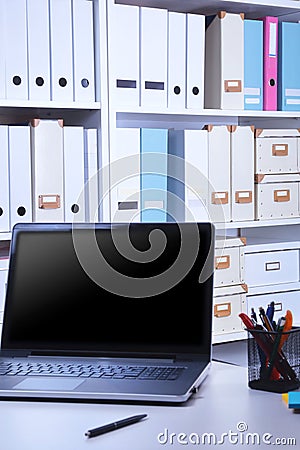 Modern office interior with laptop, chairs and bookcases Stock Photo