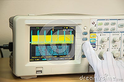 Modern oscilloscope, man`s hand adjusting wave signals, closeup Stock Photo