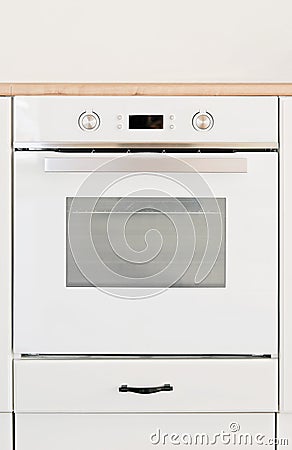 modern oven built in kitchen furniture, front view, vertical. White cooker with heat control buttons. Stock Photo