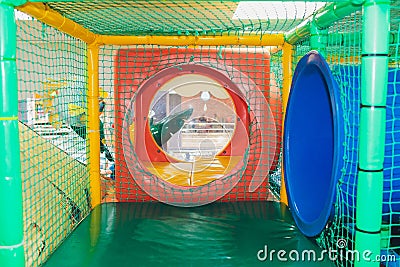 Modern playground indoor. Kids jungle in a play room. Round tunnel in children gym. Stock Photo