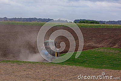 A modern powerful tractor plows a field. Stock Photo