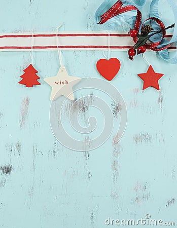 Modern red and white hanging Christmas decorations on aqua blue wood background. Vertical. Stock Photo