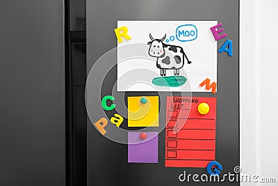 Modern refrigerator with child`s drawing, notes and magnets Stock Photo