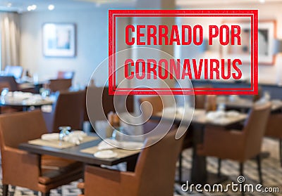 Modern restaurant with tables closed and sign in spanish saying Closed due to Coronavirus Stock Photo