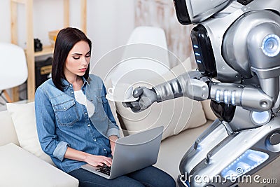 Modern robot giving cup of coffee to cheerless girl Stock Photo