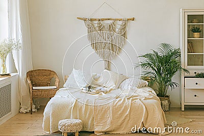 Modern romantic boho style bedroom interior with macrame wall panel Stock Photo