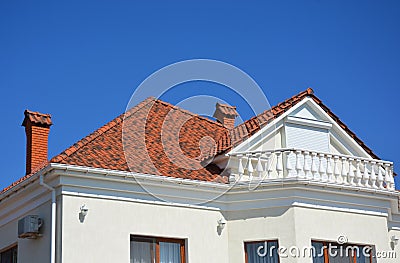 Luxury roofing constraction with natural clay roof tiles, house attic balcony and metal shutters, blinds. Stock Photo