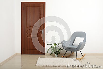 Modern room interior with brown door and rocking chair Stock Photo