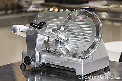 Modern Semi automatic frozen meat slicer electric machine for food industrial on table Stock Photo
