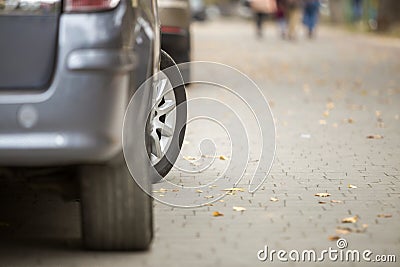 Modern silver car parked on paved sunny quiet suburban street on sunny day. Transportation, comfort, speed concept Stock Photo