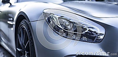 Modern silver car parking on the road. Close up. Headlights detail. Stock Photo