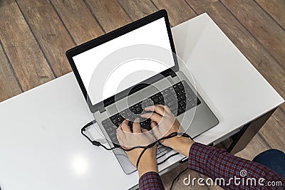 Modern problems concept. Man typing on laptop with hands tangled in the cable Stock Photo