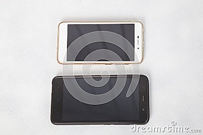 Modern smartphones are lying on the white surface of the table Stock Photo