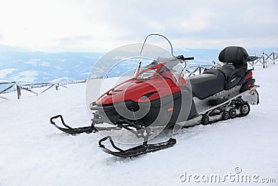 Modern snowmobile on hill at mountain ski resort Stock Photo