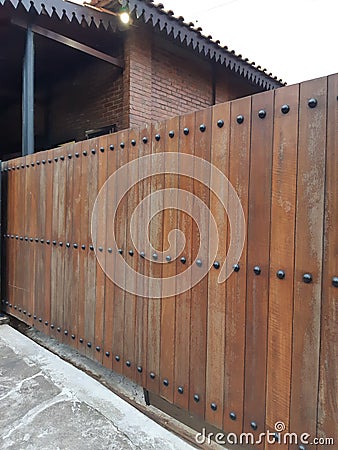 Modern solid wood fence in brown color with iron nails detail Stock Photo