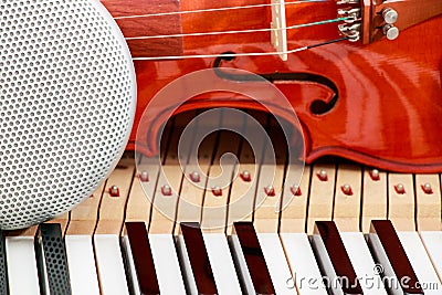 modern speaker and classical violin on white and black piano keys close-up background Stock Photo