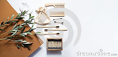 Modern still life scene with olive branch, zero waste products for the home. Bamboo toothbrushes and ear sticks, reusable cotton s Stock Photo