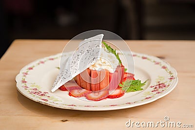 Modern strawberry rhubarb cheesecake dessert with a meringue wafer. Stock Photo