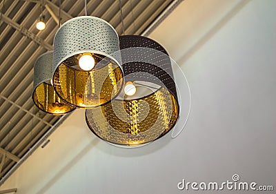 Modern style bronze decorative lamps and Golden lampshades hang on a long rope, industrial ceiling, interior design Stock Photo