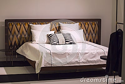 Modern stylish bedroom, double bed with headrest in the Art Nouveau style, retro, with a zigzag pattern, loft bedroom Stock Photo