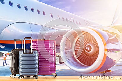 Modern suitcases baggage for travelling or business trip on wooden floor against air plane engine background Stock Photo