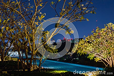 Modern swimming pool illuminates with lights on a roof of hotel or house at night Stock Photo