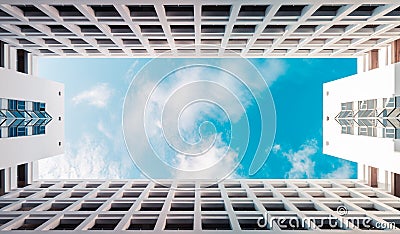 Modern symmetrical architecture building with blue cloudy sky, abstract low angle clouds skyscaper background with copy space Stock Photo