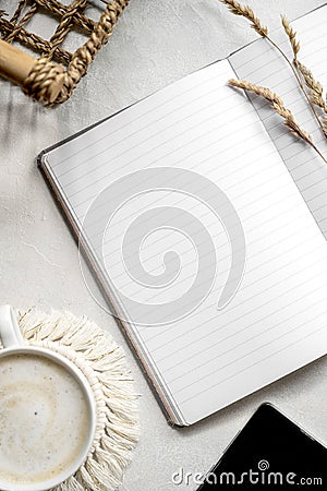 Modern tabletop with with open notebook mockup, cup of coffee, dried plants. Flat lay, minimal style workspace Stock Photo