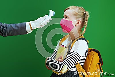 Modern teacher woman and school girl measures temperature Stock Photo